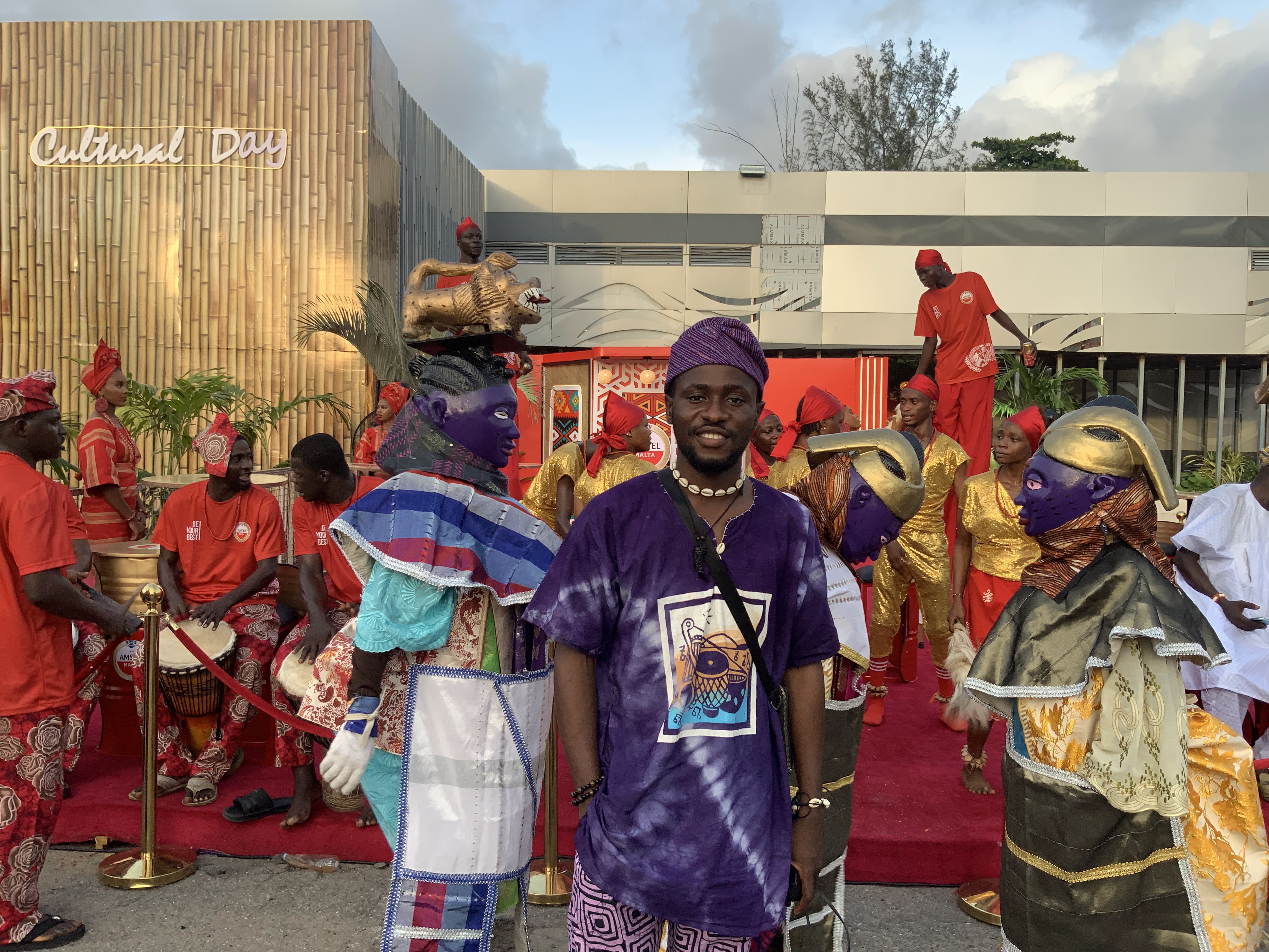 Director at a cultural festival with traditional masquerade performers